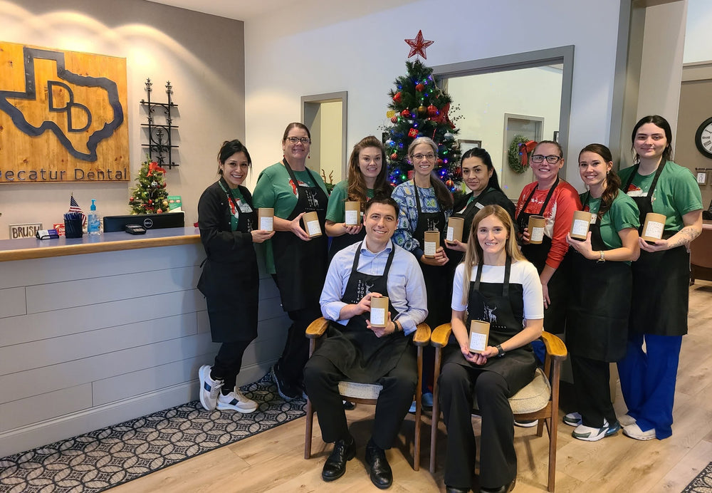 Dental office team holding candles at a holiday workshop