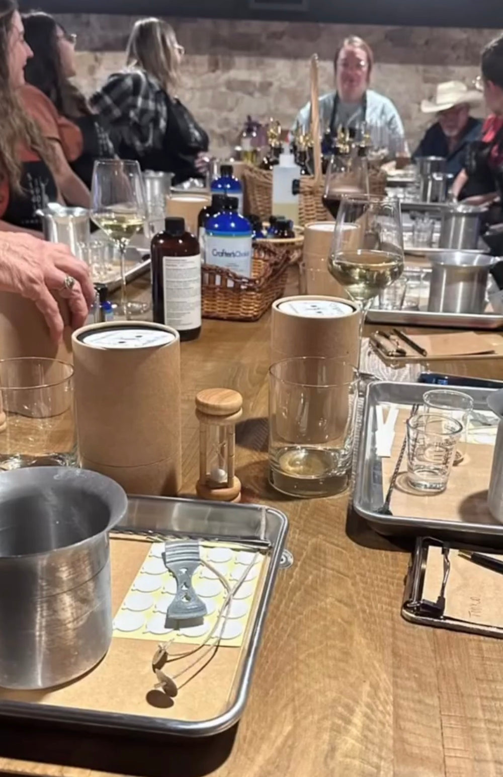 Guests exploring fragrance bottles around a workshop table