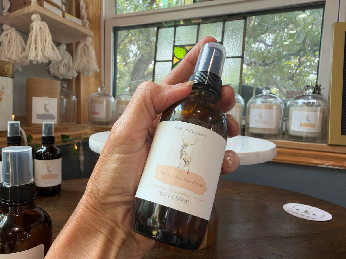 Orange Blossom Honey room spray held in the Studio 1903 sunroom
