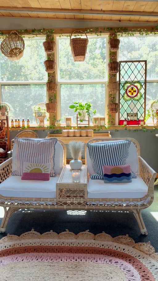 Studio 1903 Candle Co. sunroom with wicker seating and candles